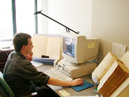 Een onderzoeker van het ING aan het werk met oude boeken